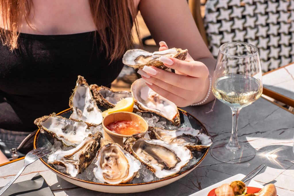 woman dines on fresh oyster platter